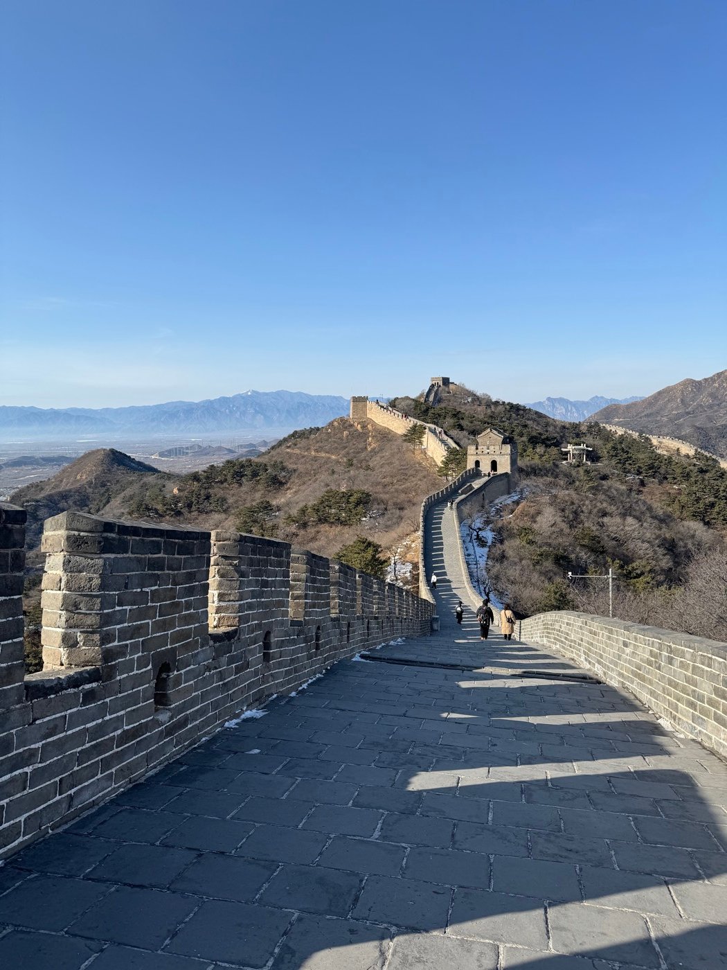 A stretch of the Great Wall of China winding over the mountains under a clear winter sky near Beijing.