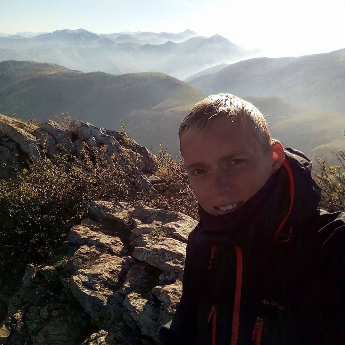 Peter at a mountain summit with layered peaks fading into the distance, during the Camino de Santiago.